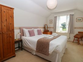 A bedroom with a bed and wardrobe at Iona Cottage in Southwold