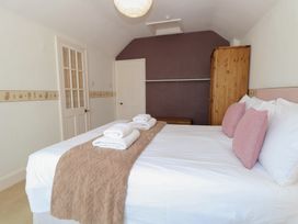 A bedroom with a bed and towels at Iona Cottage Southwold