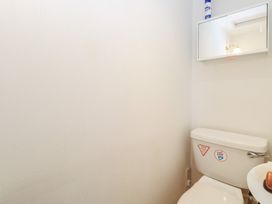 A bathroom with a toilet and a mirror at Iona Cottage in Southwold