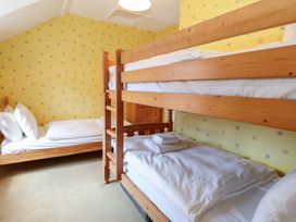 A bedroom with a bunk bed and a single bed at Iona Cottage Southwold