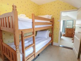 A bedroom with a bunk bed and dresser at Iona Cottage Southwold