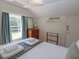 A bedroom with a bed and dresser at Iona Cottage in Southwold