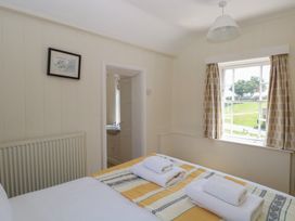 A bedroom with a bed and towels at Iona Cottage Southwold