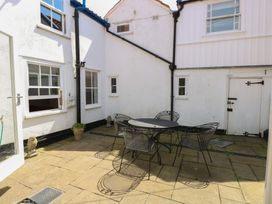 An outdoor patio area with a table and chairs at Iona Cottage Southwold