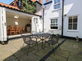 An outdoor seating area with a table and chairs at Iona Cottage Southwold