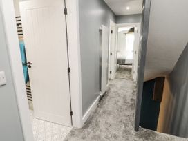 A hallway with a door and stairs at 10 Keekle Terrace in Cleator Moor