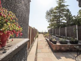 A garden with a pathway and flower pots at 10 Keekle Terrace in Cleator Moor