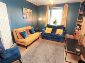 A living room with yellow and blue sofas and a coffee table at 10 Keekle Terrace in Keekle near Cleator Moor