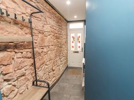 A hallway with a stone wall and bench at 10 Keekle Terrace in Keekle near Cleator Moor