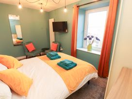 A bedroom with a bed and armchair at 10 Keekle Terrace in Keekle near Cleator Moor