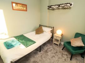 A bedroom with a bed and a chair at 10 Keekle Terrace in Keekle near Cleator Moor