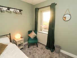 A bedroom featuring a bed, side table, chair and window at 10 Keekle Terrace Keekle near Cleator Moor