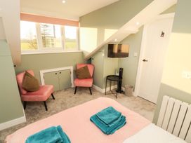 A bedroom with a bed and two chairs at 10 Keekle Terrace in Keekle near Cleator Moor