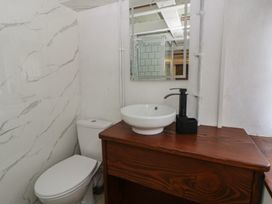 A bathroom with a toilet, sink, and mirror at The Old Workshop in Dre-Fach near Lampeter