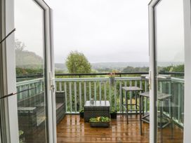 A balcony with outdoor furniture and potted plants overlooking a green landscape at Terrace View in Trefriw near Llanrwst