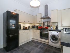 A kitchen with black refrigerator washing machine oven and cream cabinets at Terrace View in Trefriw near Llanrwst