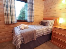 A bedroom with a bed and lamp at Elderberrys Lodge in Bideford