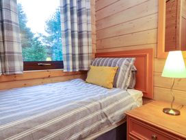 A bedroom with a bed and lamp at Elderberrys Lodge in Bideford