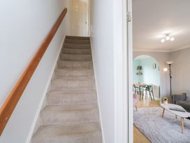 A staircase leading to an upper floor with a view of a living area at 20 Honeycroft Bourton-On-The-Water