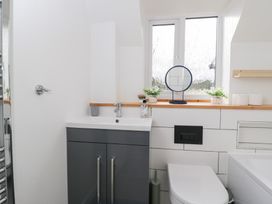 A bathroom with sink, toilet and mirror at 20 Honeycroft, Bourton-On-The-Water