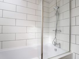 A bathroom with a bathtub and shower setup at 20 Honeycroft in Bourton-On-The-Water