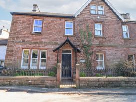 Front view of a two story stone house with multiple windows a black door and a metal gate at Allendale House in Armathwaite