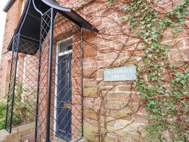 An entrance door with a metal canopy and climbing ivy on the brick wall at Allendale House in Armathwaite