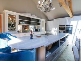 A kitchen with a large island and blue chairs at Allendale House in Armathwaite