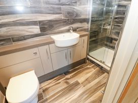 A bathroom with a toilet a sink built into cabinetry and a glass shower enclosure at Allendale House in Armathwaite