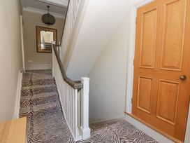 A staircase with zebra print carpet a wooden door and a framed mirror at Allendale House in Armathwaite