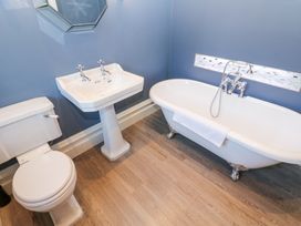 A bathroom with a toilet sink and clawfoot bathtub with towel on the side at Allendale House in Armathwaite