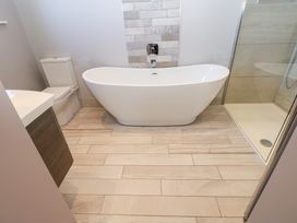 A bathroom with a freestanding bathtub a toilet a shower with glass door and a sink cabinet at Allendale House in Armathwaite