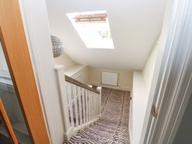 A staircase with patterned carpet leading down under a skylight at Allendale House in Armathwaite