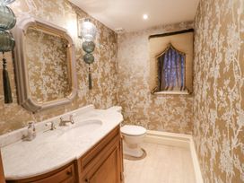 A bathroom with a wooden vanity with marble countertop and a toilet at Allendale House in Armathwaite