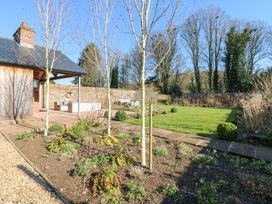 A garden with trees plants grass and outdoor seating area at Allendale House in Armathwaite