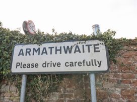 A road sign saying Armathwaite Please drive carefully next to a brick wall with ivy at Allendale House in Armathwaite