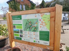 A wooden information board with a map and details about Armathwaite in an outdoor setting near buildings