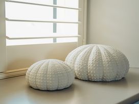 Two white sea urchin shell decorations on a windowsill at The Old Watermill in Beadnell