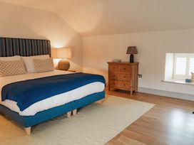 A bedroom with a bed a wooden dresser and two lamps at The Old Watermill in Beadnell