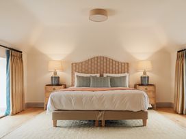 A bedroom with a bed bedside tables lamps and curtains at The Old Watermill in Beadnell