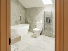 A bathroom with a bathtub toilet towel rack and sink at The Old Watermill in Beadnell