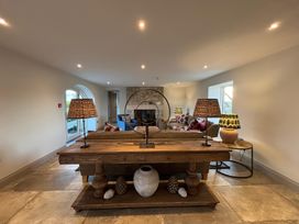 A living room with a wooden console table lamps and a stone fireplace at The Old Watermill in Beadnell