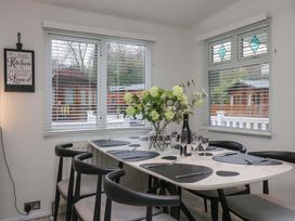 A dining room with a table set for a meal at Cosy Corner White Cross Bay near Troutbeck Bridge