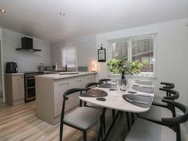 A kitchen with a dining table and chairs at Cosy Corner White Cross Bay near Troutbeck Bridge