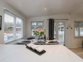 A dining room with a table and chairs at Cosy Corner White Cross Bay near Troutbeck Bridge