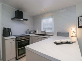 A kitchen with stove and sink at Cosy Corner White Cross Bay near Troutbeck Bridge