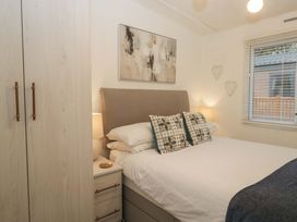 A bedroom with a bed and wardrobe at Cosy Corner White Cross Bay near Troutbeck Bridge