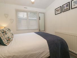 A bedroom with a bed and window at Cosy Corner White Cross Bay near Troutbeck Bridge