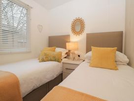 A bedroom with two single beds and a lamp at Cosy Corner in White Cross Bay near Troutbeck Bridge