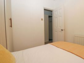 A bedroom with a bed and wardrobe at Cosy Corner White Cross Bay near Troutbeck Bridge